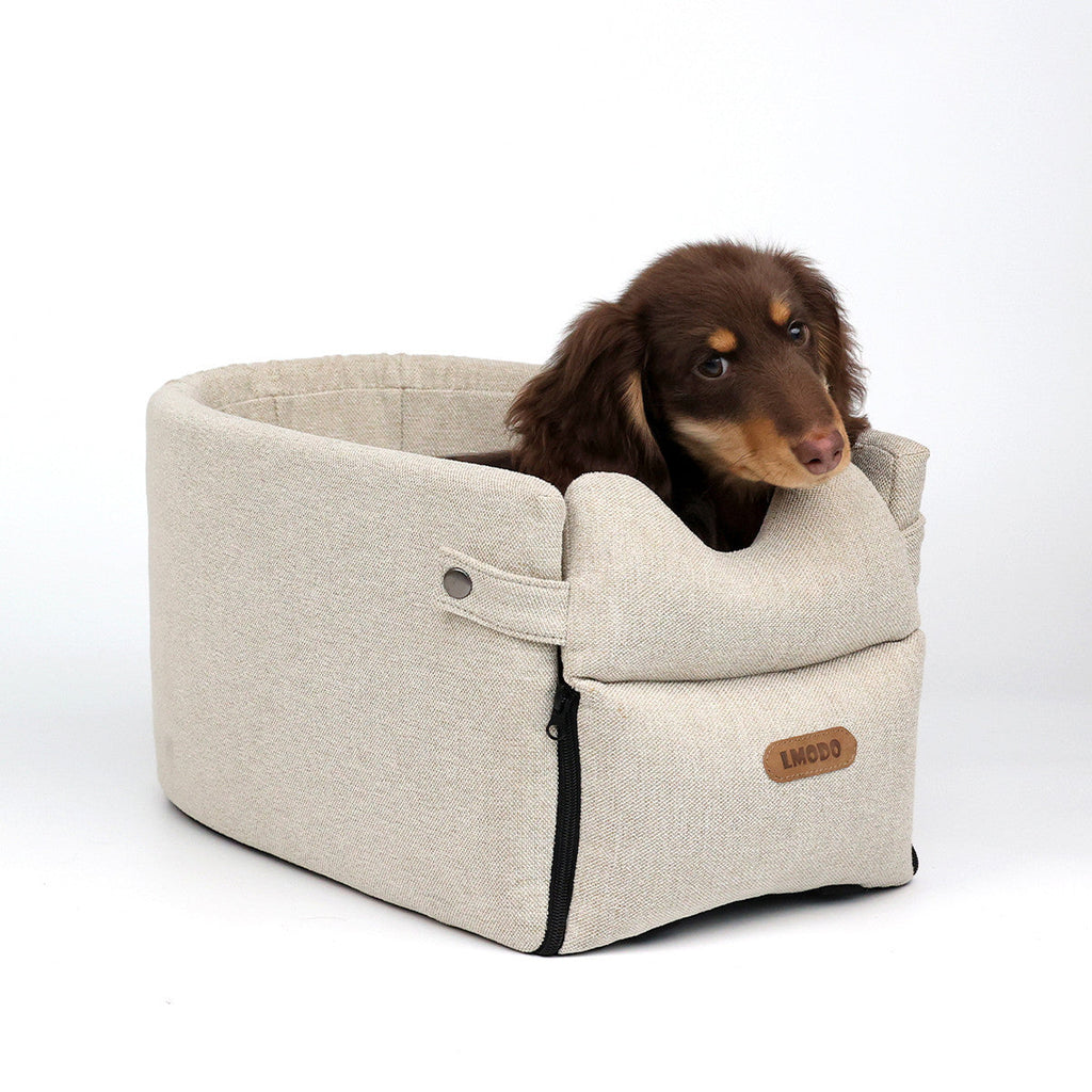 Dog car seat bed in Beige with a small long-haired brown dog sitting inside