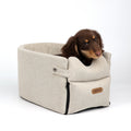 Dog car seat bed in Beige with a small long-haired brown dog sitting inside